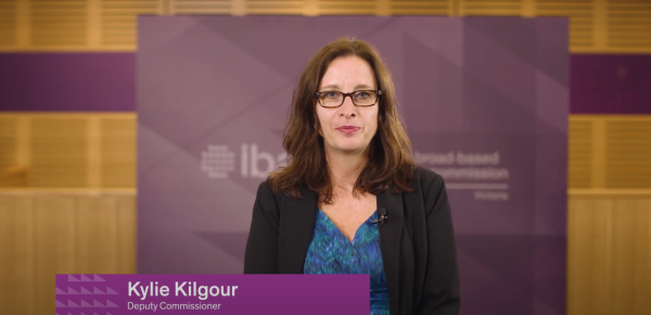 Image of Kylie Kilgour in front of IBAC banner