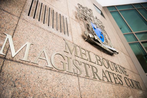 An image looking up at the Melbourne Magistrates Court coat of arms, featuring a shield with a native animal on either side