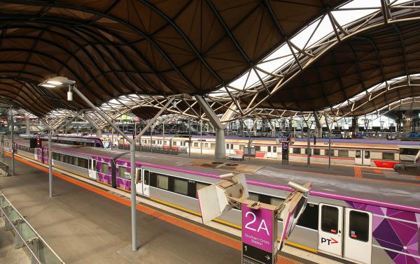 A series of V-line trains with purple signage docked at Southern Cross station