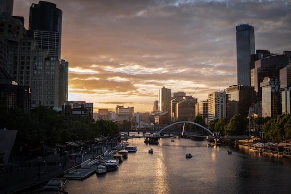 Tall buildings of either side of the Yarra river, in Melbourne, at sunset. Photo by Jesse G-C on Unsplash